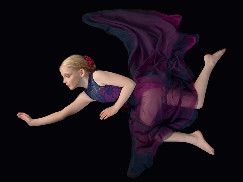 dayton dance conservatory dancer surreal flying pose in colorful outfit